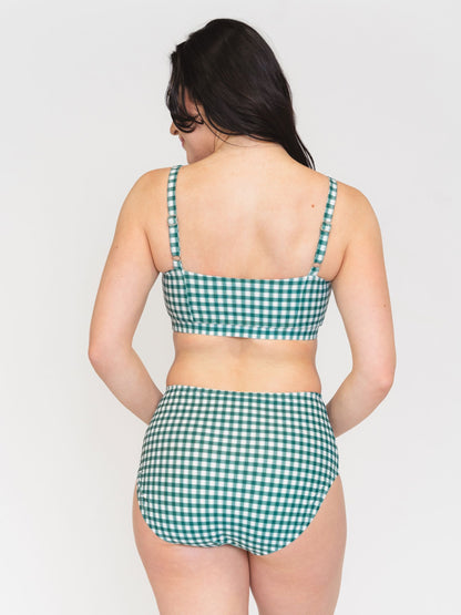 Woman wearing a green checkered bikini set on a white background