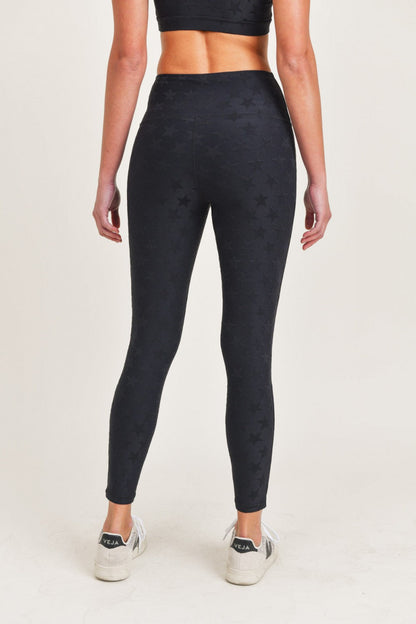 Person wearing black patterned leggings on a white background