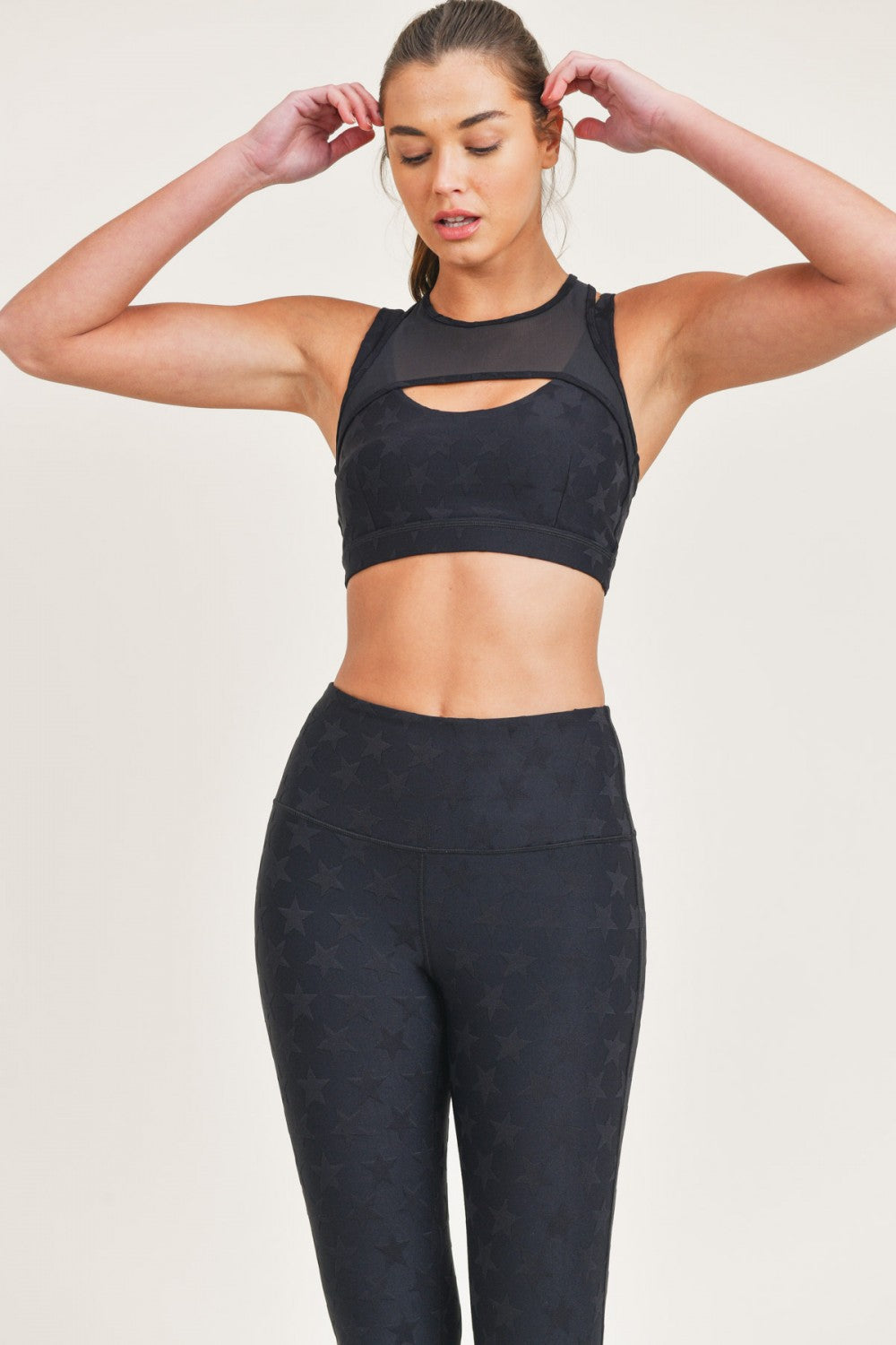 Woman wearing a black athletic outfit on a light background