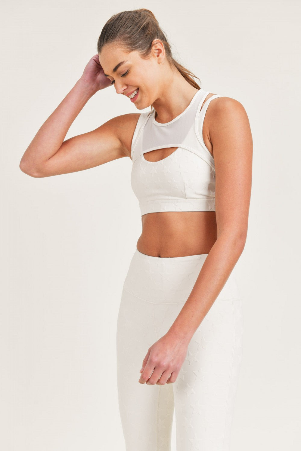 Woman wearing a white athletic outfit on a plain background