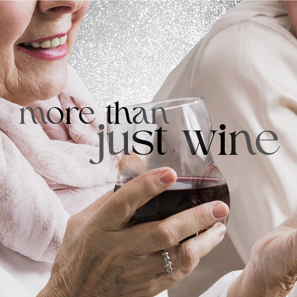 Person holding a glass of red wine with 'more than just wine' text overlay.