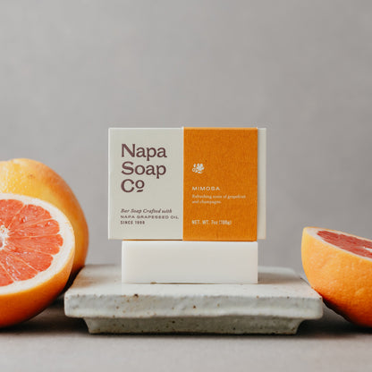 Napa Soap Co. bar of soap with a box on a stone surface with grapefruits.