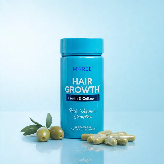 A bright blue bottle of MARÉE Hair Growth Biotin & Collagen Hair Vitamin Complex, styled with green olives and capsules on a light blue reflective surface.