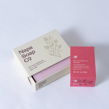 Buttermilk Rose Bar Soap unwrapped beside its carton, on a white background