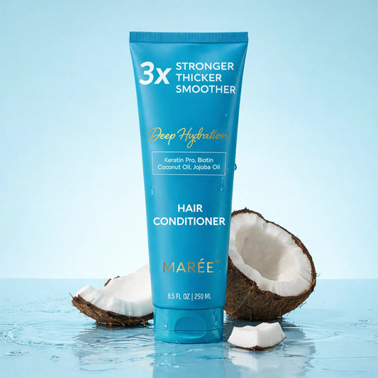 A tube of Marée Hair Conditioner stands upright on water with coconut halves around it. The tube is bright blue with white and gold text reading '3x Stronger Thicker Smoother' and 'Hair Conditioner.
