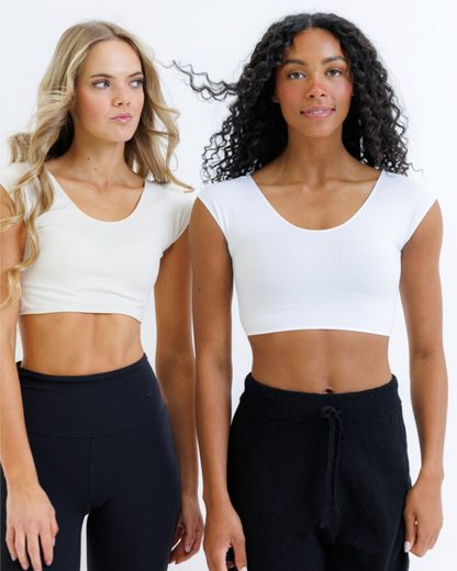 Two women modeling white scoop-neck crop top sweaters paired with black sweatpants against a clean white studio background.