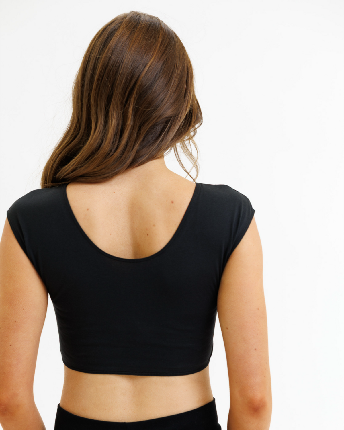 Person wearing a black crop top on a white background