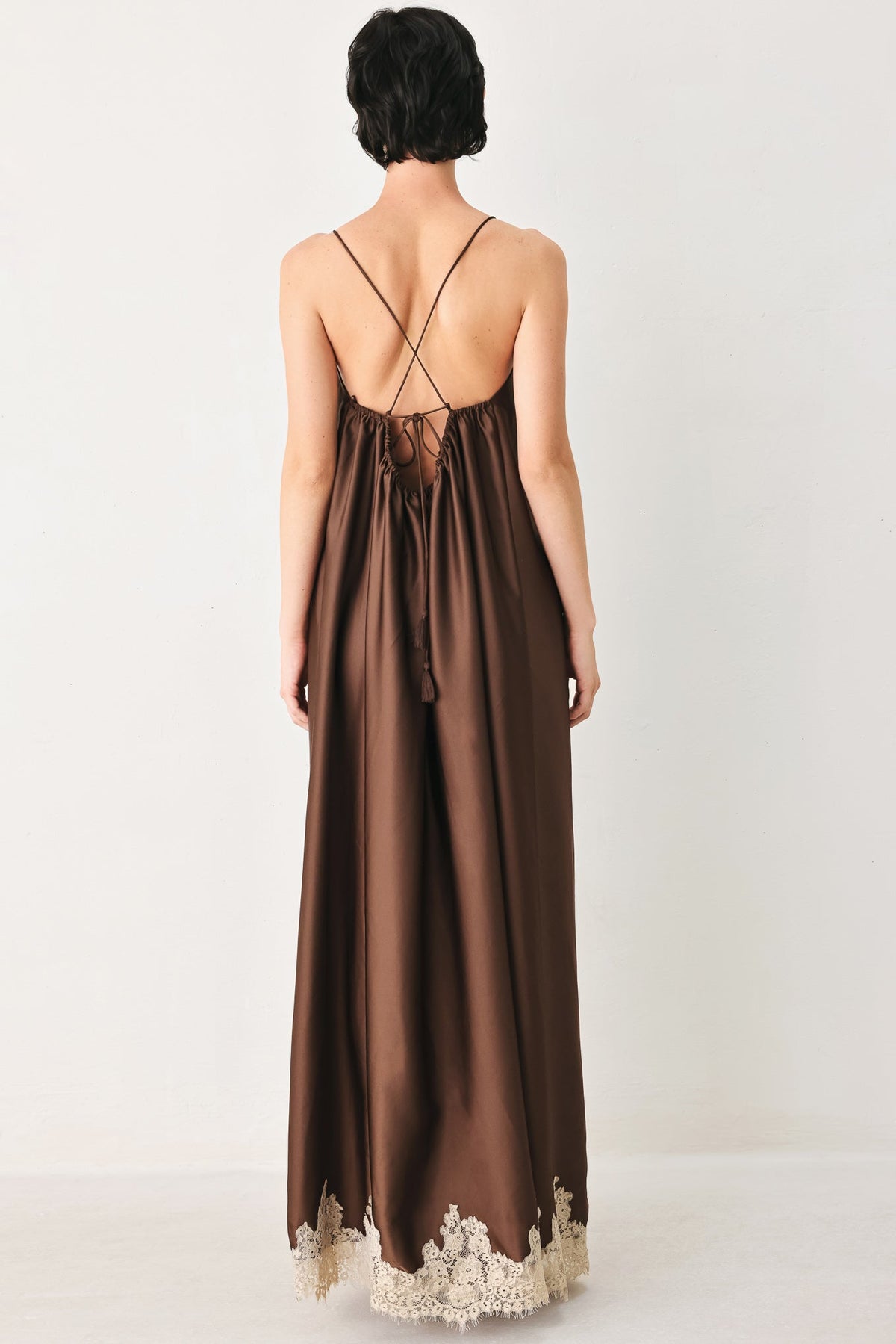 Brown satin dress with lace hem on a white background