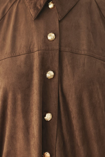 Close-up of a brown suede or faux-suede button-up shirt with decorative metallic gold buttons down the front placket and collar.