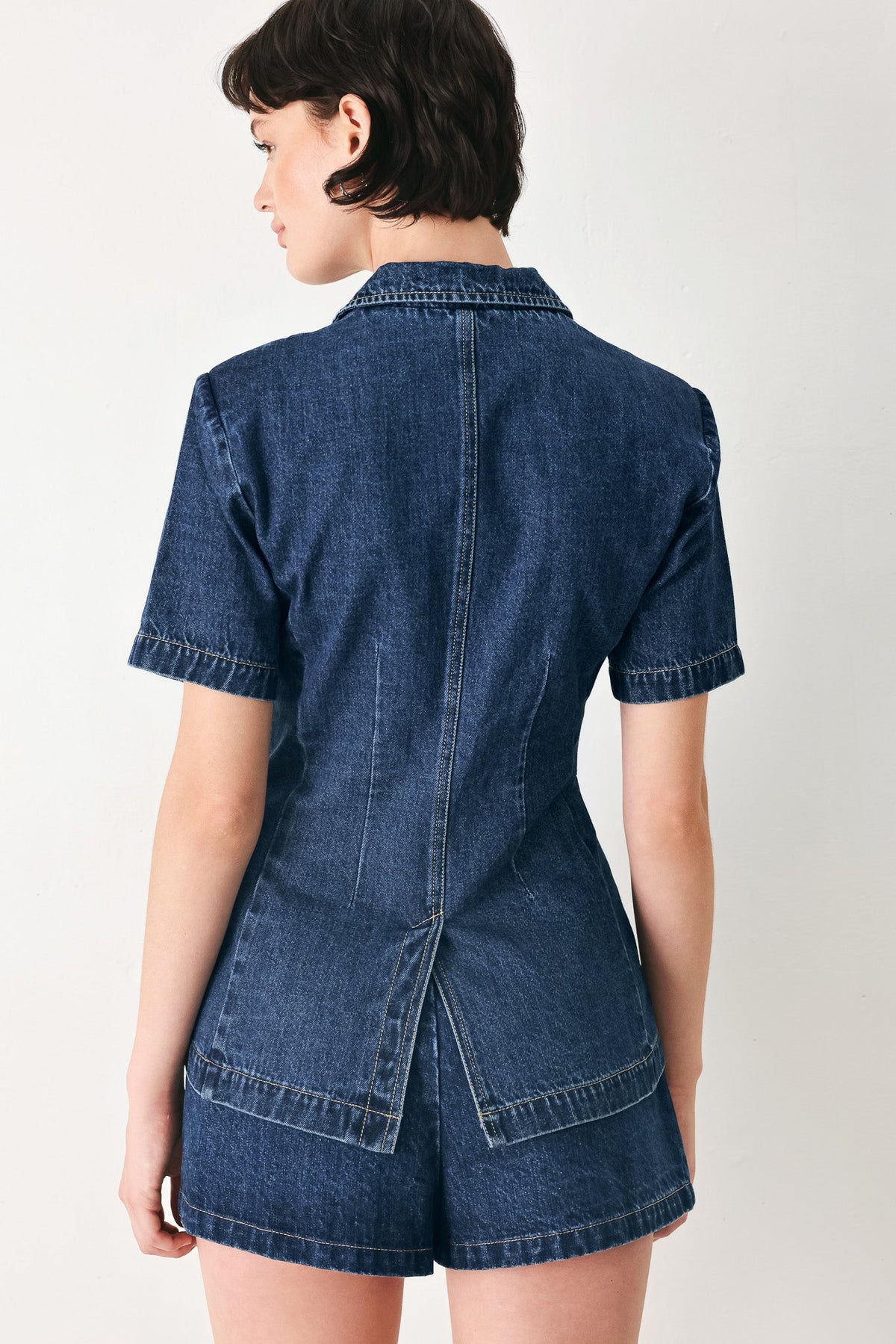 Washed denim jacket with a single-button closure at the waist.