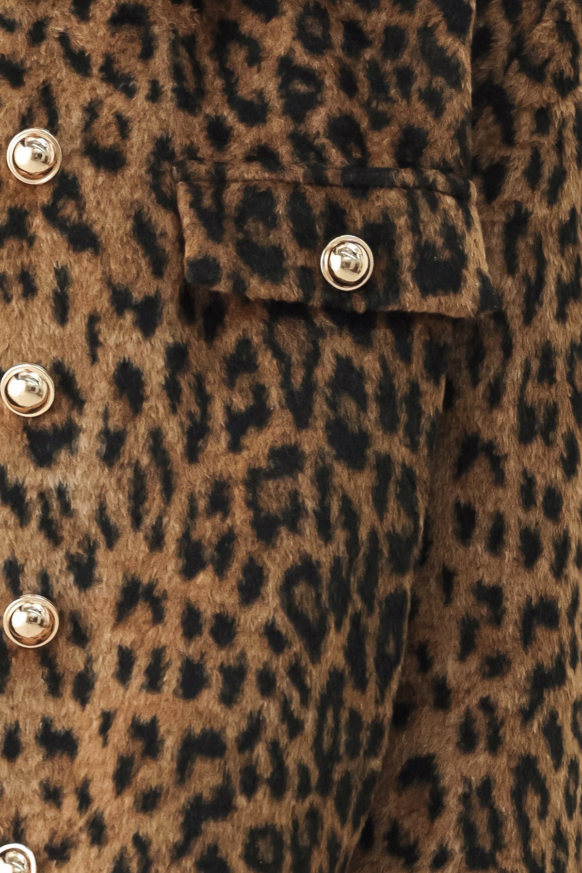 Close-up of a leopard-print faux fur jacket featuring a brown and black animal pattern with shiny gold-tone metal buttons.