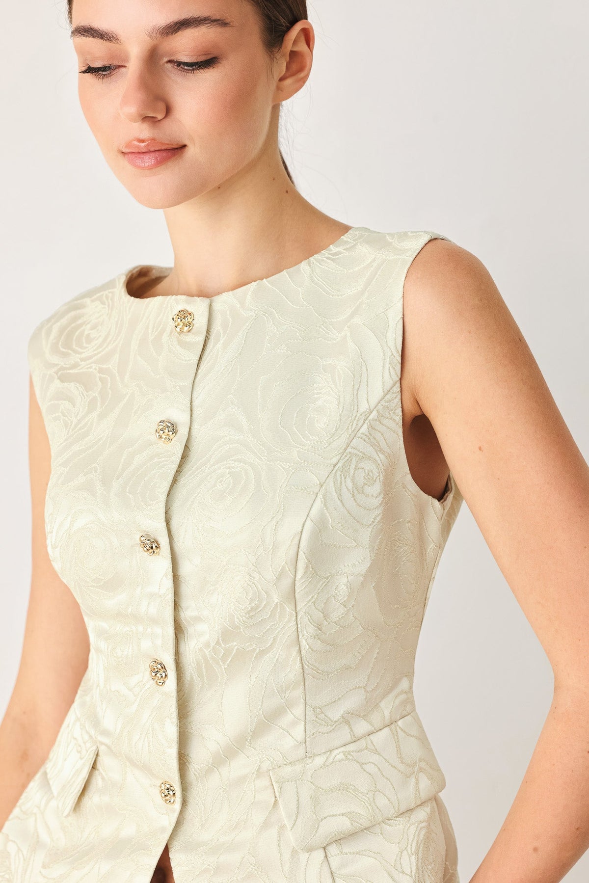 Sleeveless jacquard vest with a round neckline and front button-down closure.
