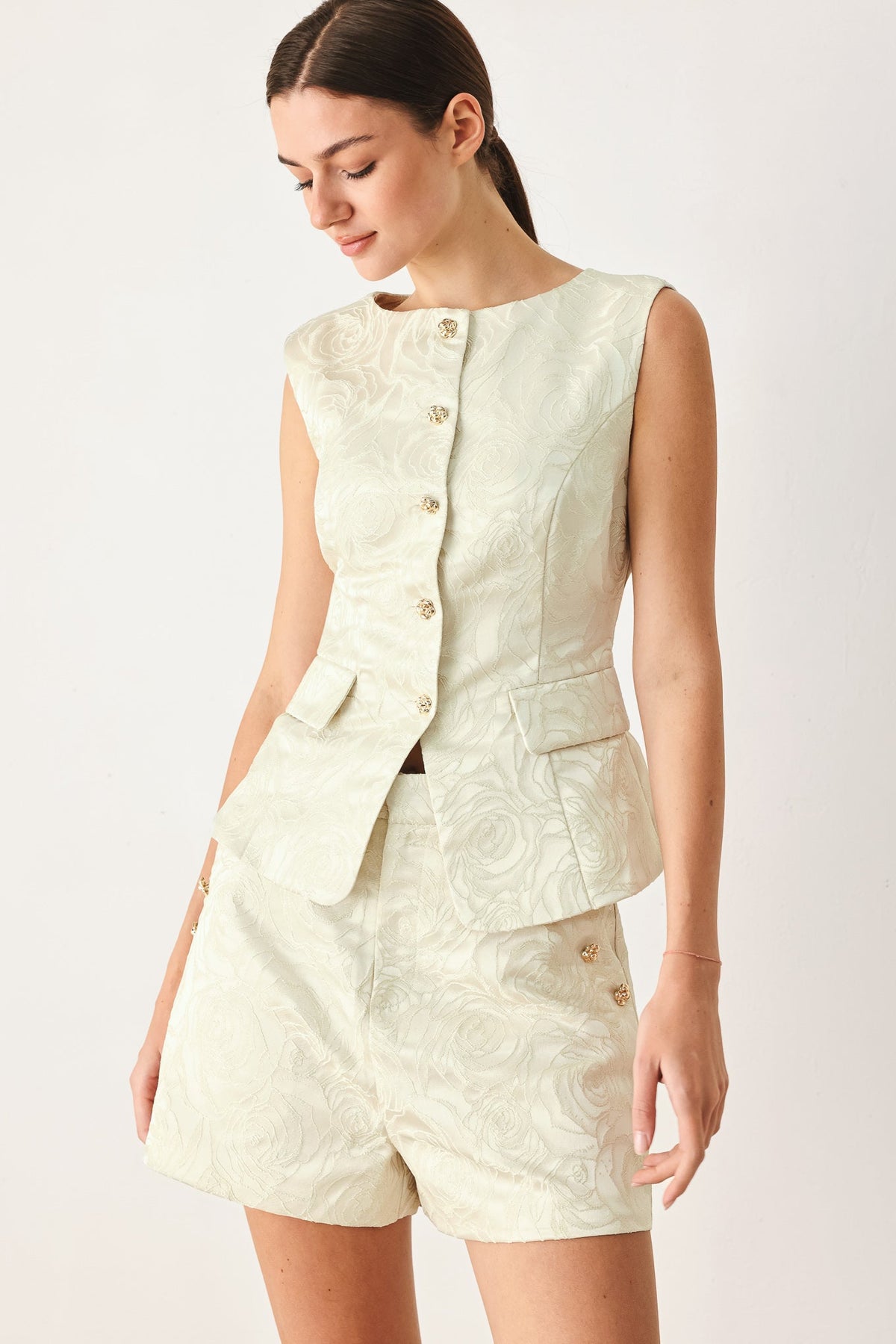 Sleeveless jacquard vest at an approximate 21 inch length, styled over trousers.