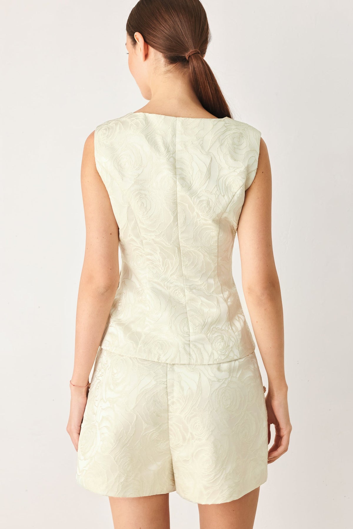 Button-down front detail on the cream and gold Marzipan Floral jacquard vest.