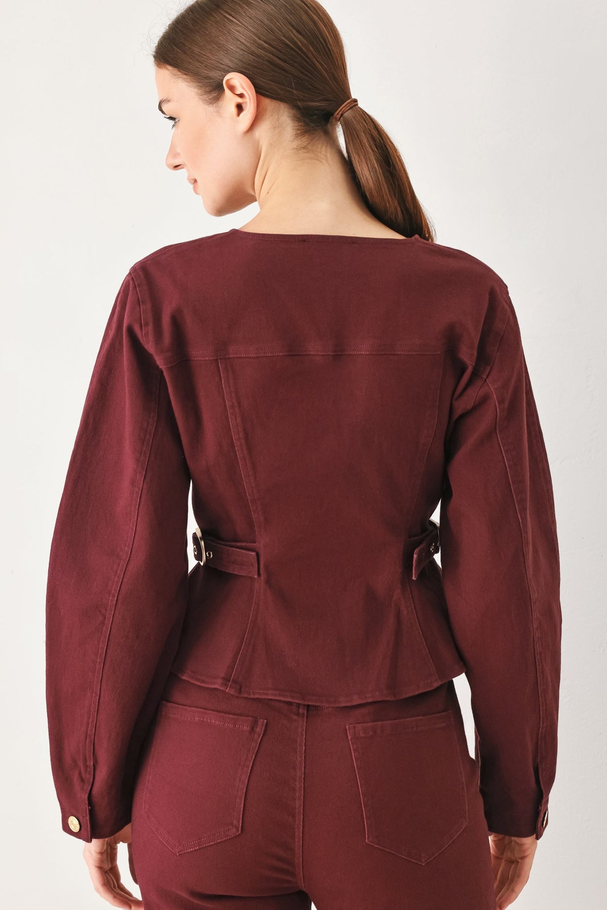 Back view of the burgundy woven jacket on a model against a plain background.