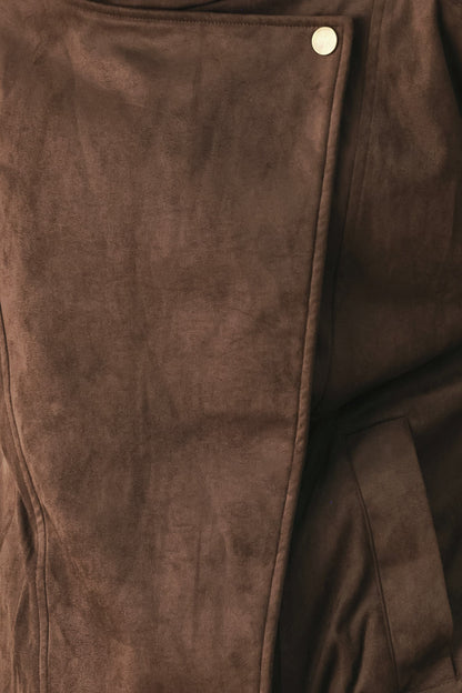 Close-up of a brown suede or faux-suede garment with a single visible light-colored snap button near the top edge.