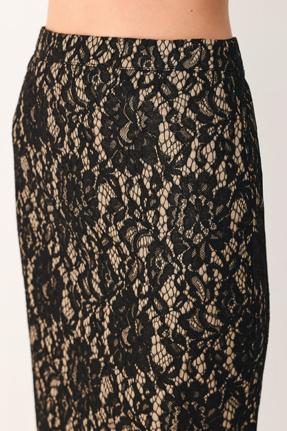 Close-up of a black lace skirt with a sheer nude underlay showing the waistband and upper hip area.