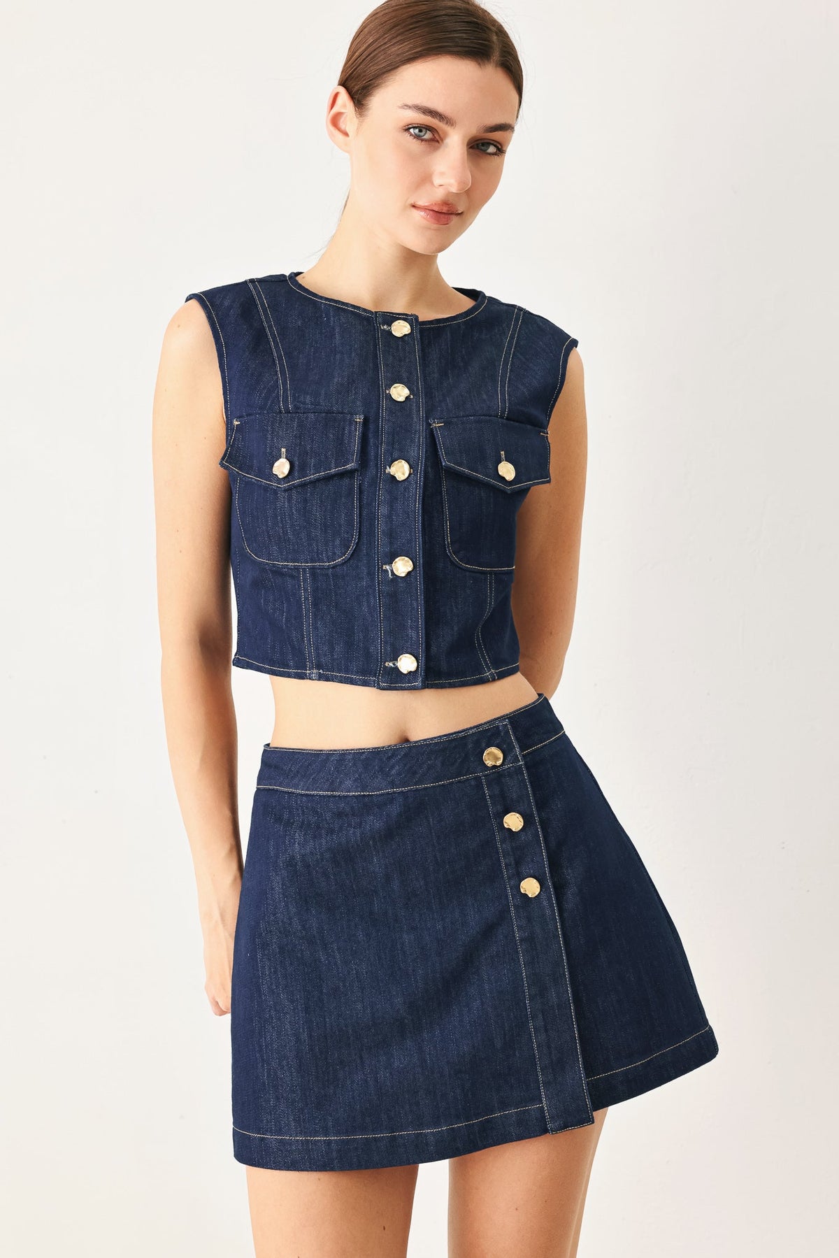Back view of the indigo denim skort on a model against a plain background.