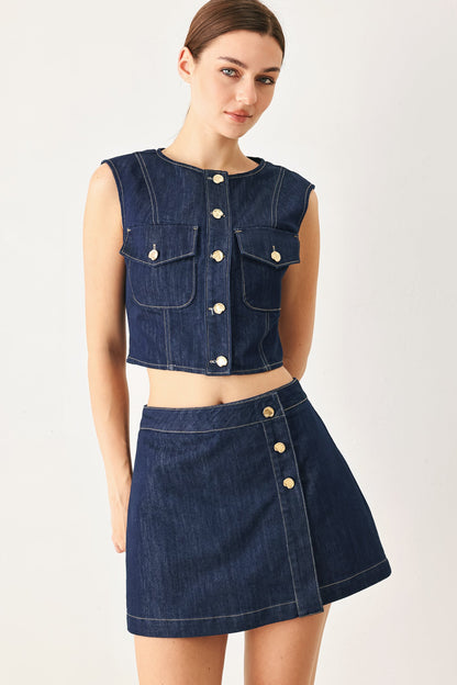 Back view of the indigo denim skort on a model against a plain background.