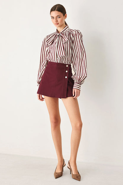 Front view of the burgundy woven skort showing the mini-skirt front over built-in shorts.