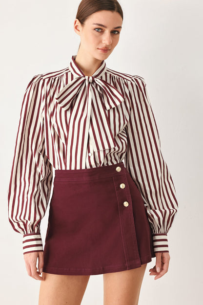 Burgundy woven skort with a button front, shown on a model against a plain studio background.