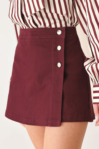 Close-up of the button details and clean front closure on the burgundy skort.