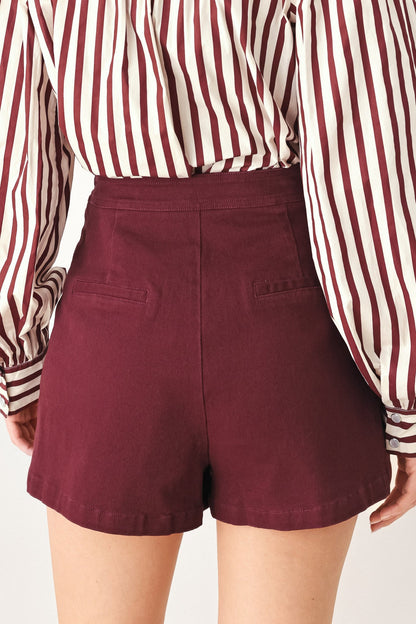 Model wearing the burgundy woven skort with the matching burgundy jacket.