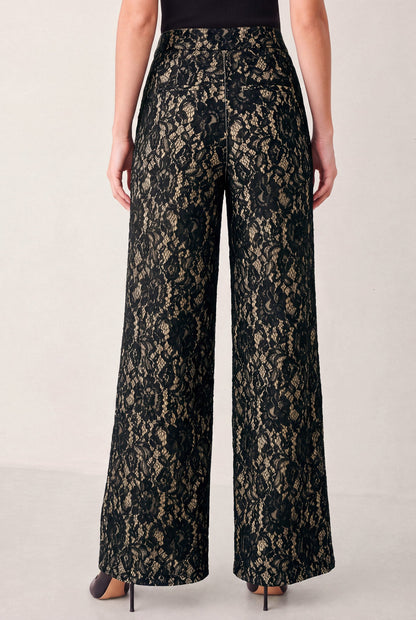 Black lace wide-leg pants with a sheer floral pattern, shown on a model from the back against a light gray studio background.