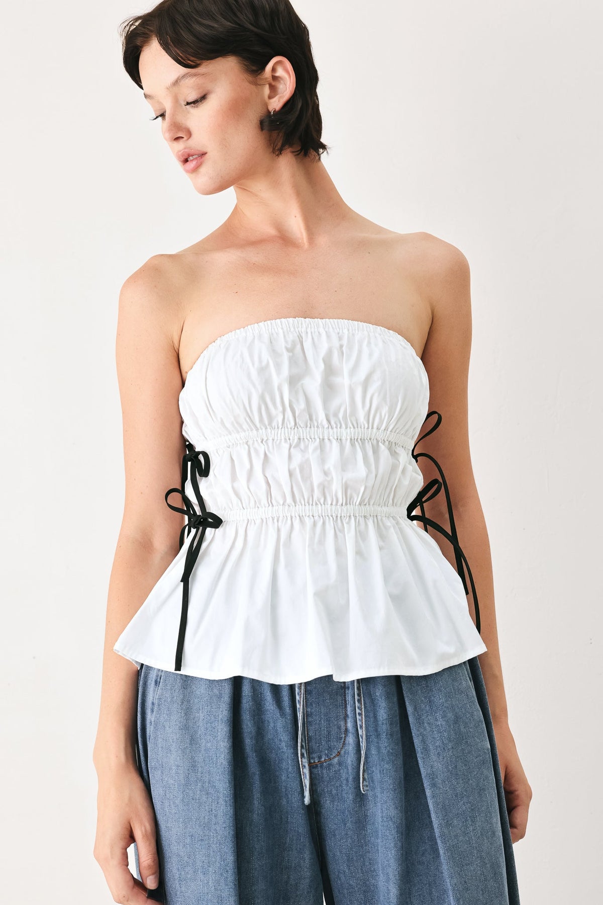 Flying Tomato Beach Club white woven strapless top with black ribbon bow ties.