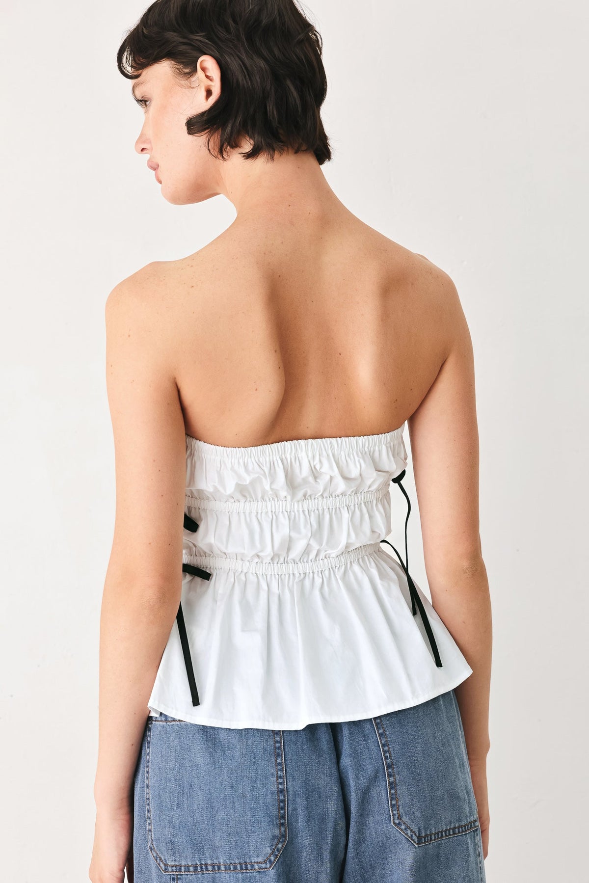 Contrast black bow ties against the crisp white cotton of the Beach Club top.