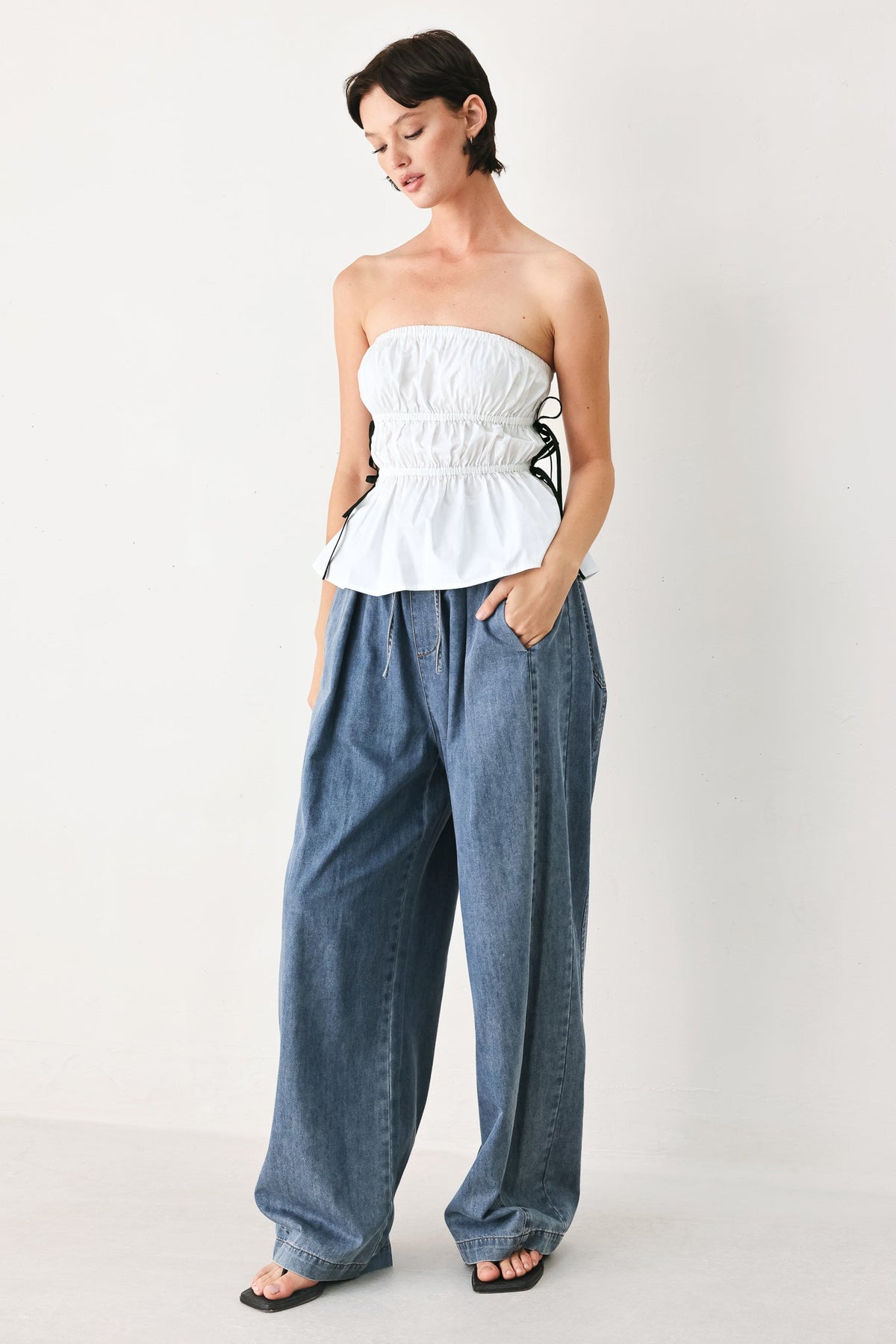 White strapless woven top at an approximate 16 inch length.