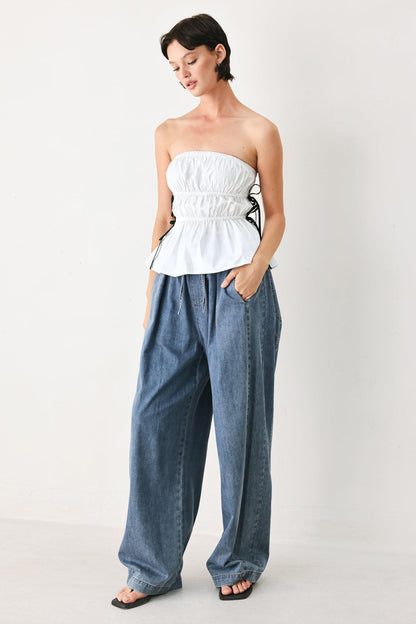 White strapless woven top at an approximate 16 inch length.