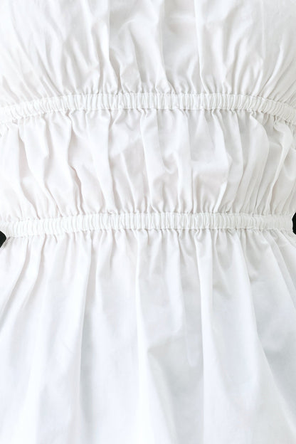 Fabric swatch showing the 100% cotton white woven fabric of the Beach Club strapless top.