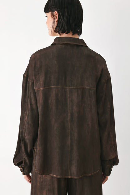 A model viewed from the back wearing a dark brown, washed-texture button-up shirt jacket and matching trousers against a plain white studio background.