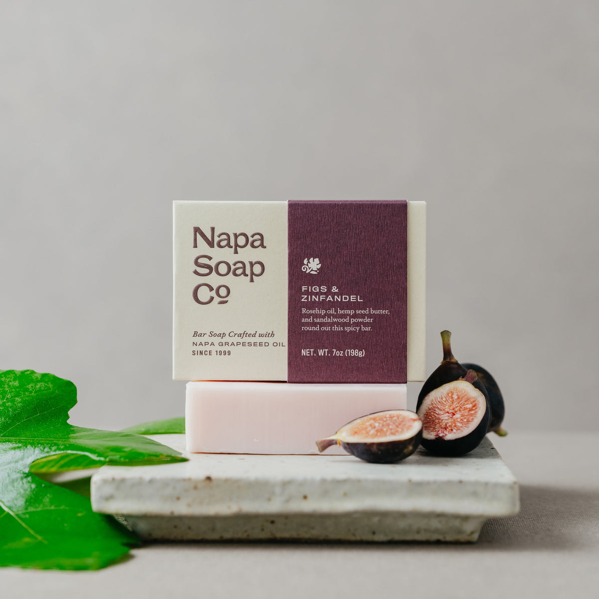 Napa Soap Co. bar soap with packaging and figs on a gray background