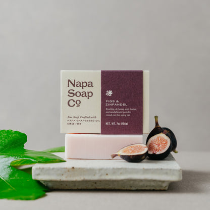 Napa Soap Co. bar soap with packaging and figs on a gray background