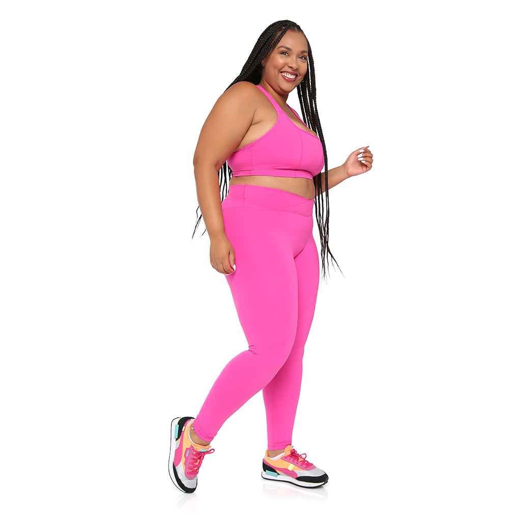 Woman wearing a bright pink athletic outfit on a white background