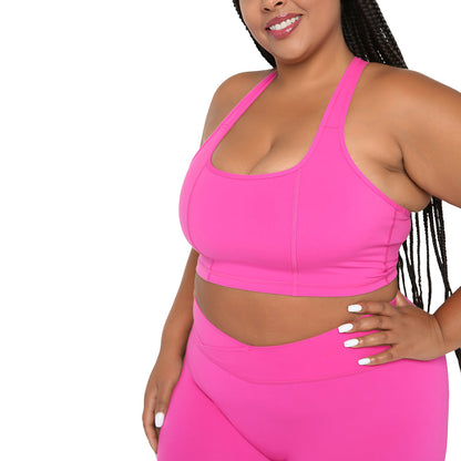 Person wearing a bright pink sports bra and leggings set on a white background