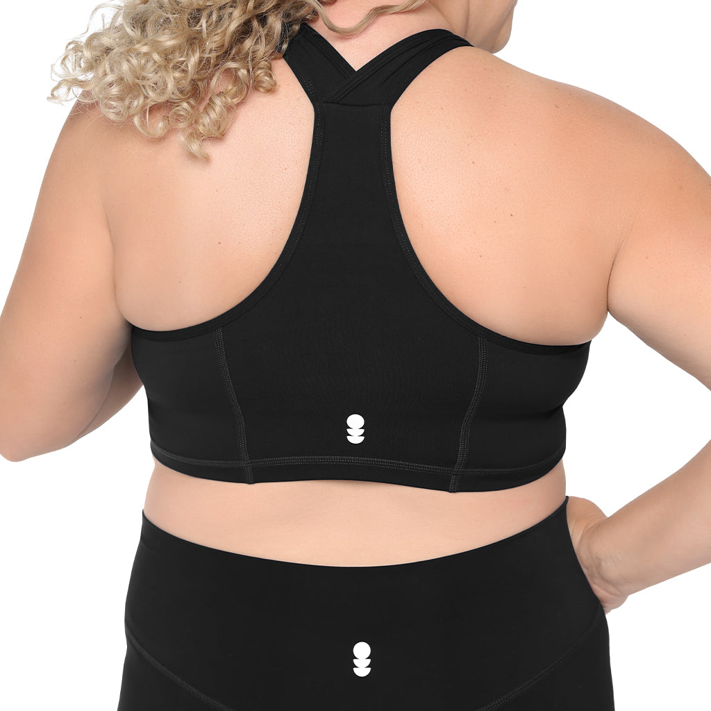Person wearing a black sports bra and leggings on a white background