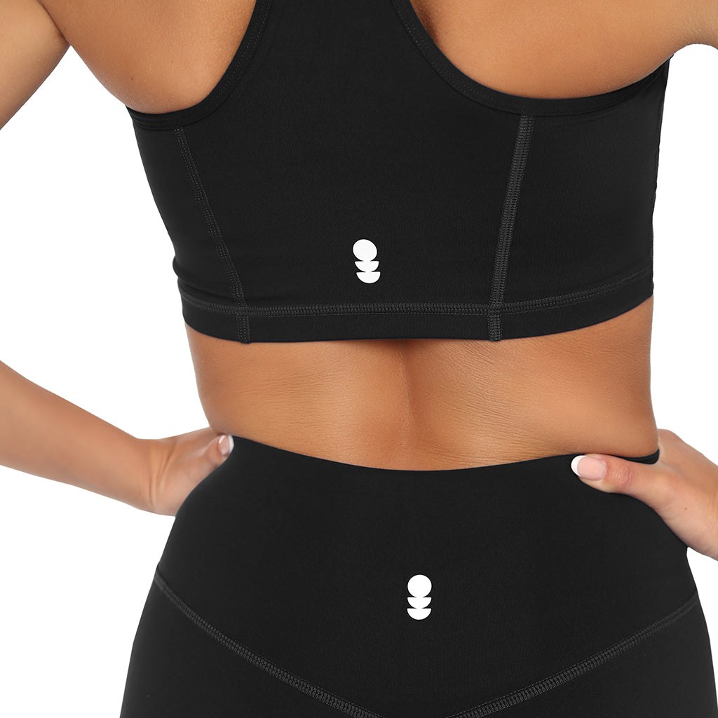 Black sports bra and leggings with a brand logo on a white background