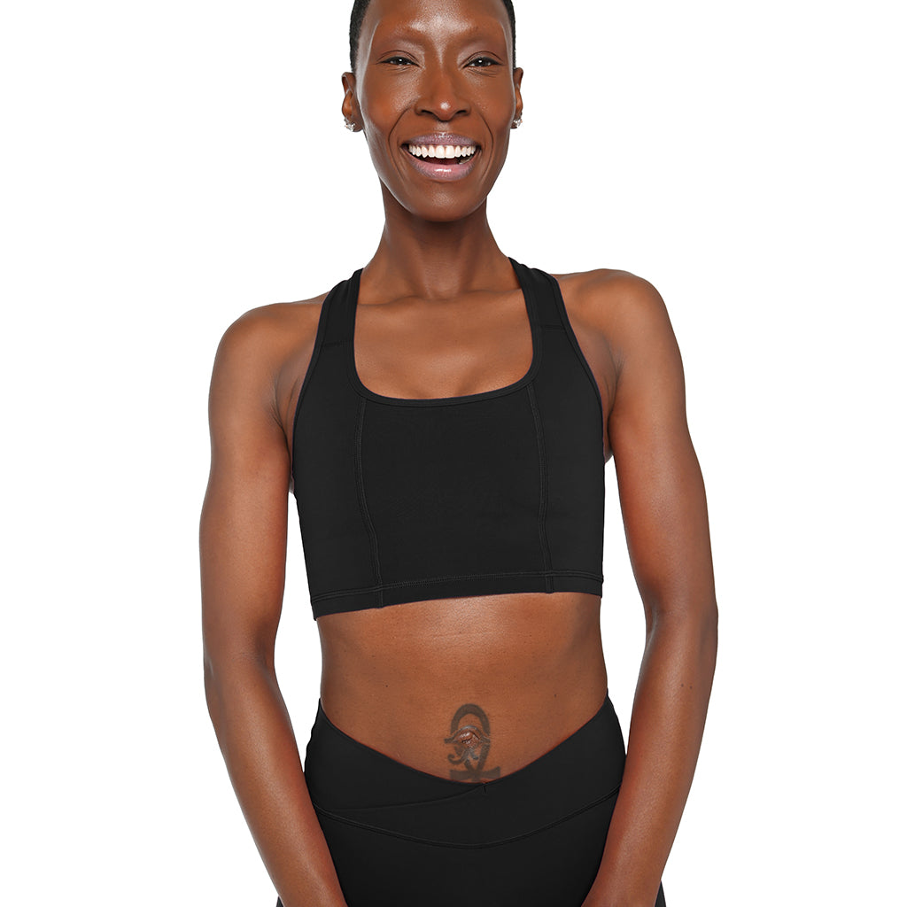 Woman wearing a black sports bra and leggings on a white background
