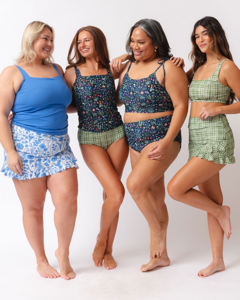 Four women wearing matching outfits with different patterns on a white background
