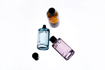 Three perfume bottles of different colors on a white background