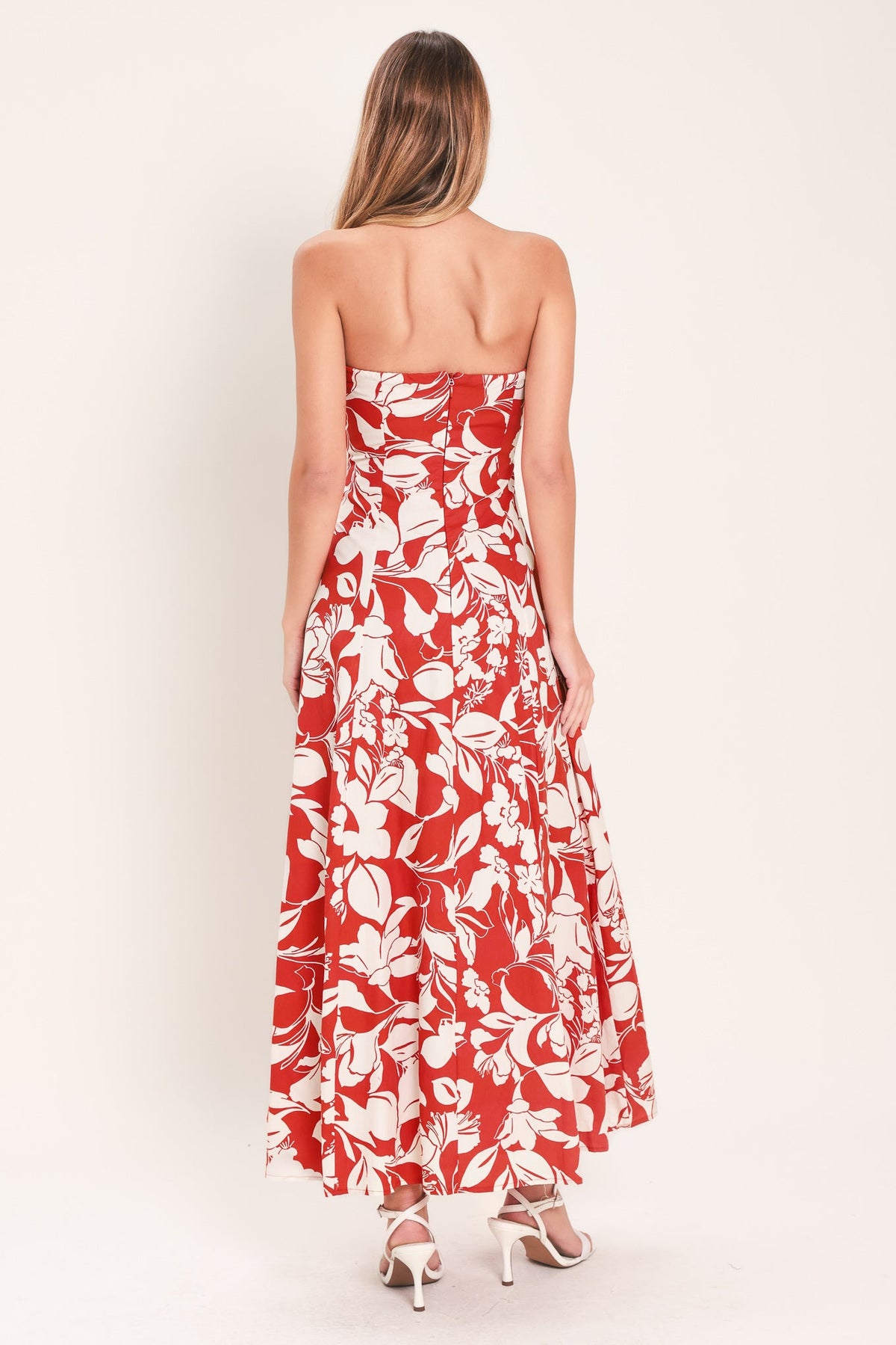 Woman wearing a strapless floral dress with a white background