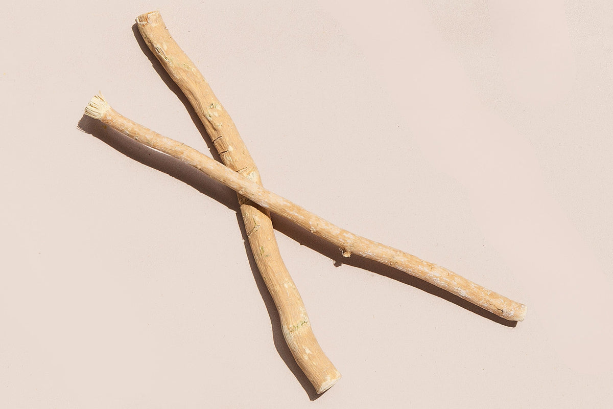 Two crossed wooden sticks on a beige background