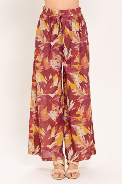 Burgundy floral print wide-leg palazzo pants shown on a model against a plain studio background.