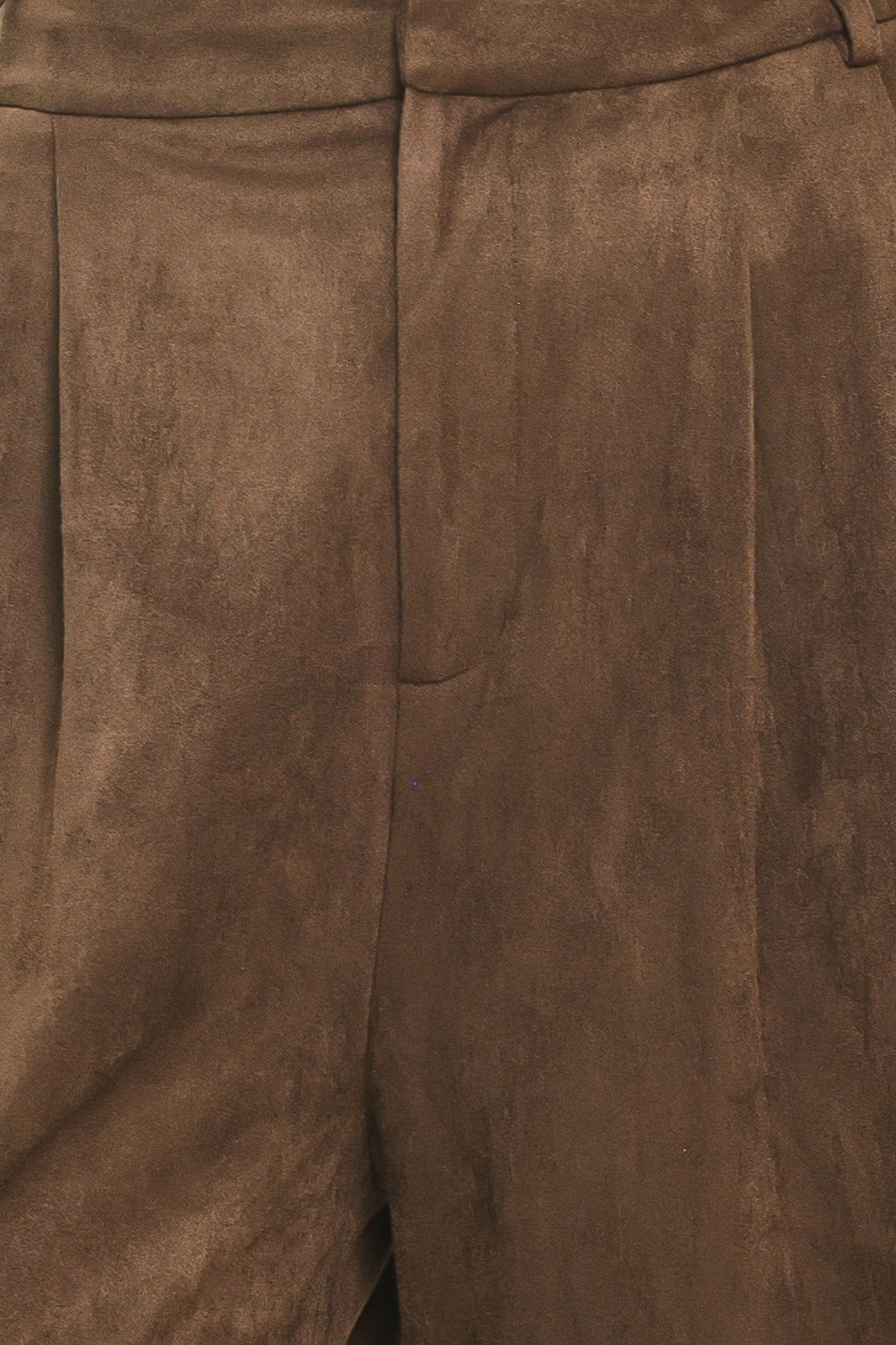 Close-up of brown suede trousers showing the fabric texture and waistband details.
