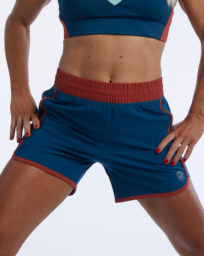 Indie Women's Sport Shorts in Dark Teal Cinnabar, action shot