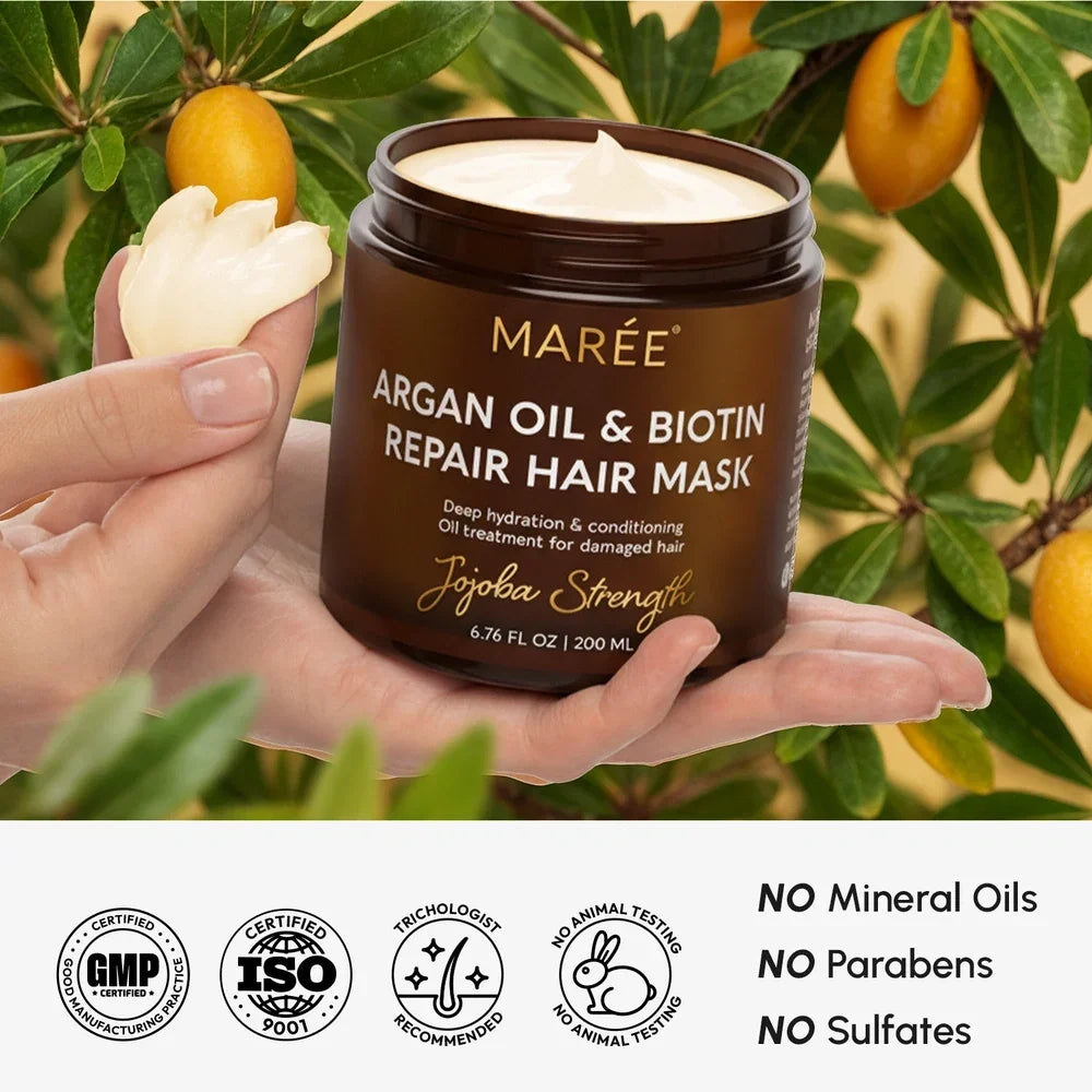 Jar of Maré Argan Oil & Biotin Repair Hair Mask held in a hand with a natural background