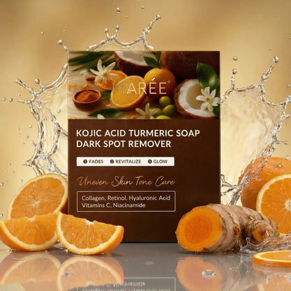 A boxed skincare product labeled 'Kojic Acid Turmeric Soap Dark Spot Remover' by MARÉE, shown on a reflective surface with orange slices, turmeric root, coconut imagery, and water splash effects against a warm beige background.